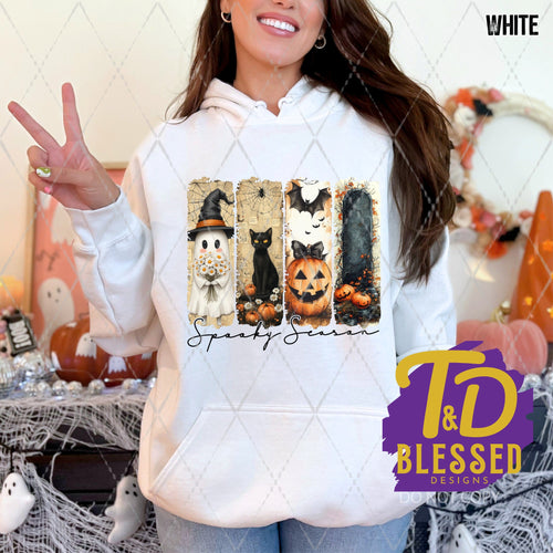 White hoodie featuring a 4-panel Halloween design with a ghost, black cat, jack-o'-lantern, and dark forest, with the words “Spooky Season” in elegant script below.