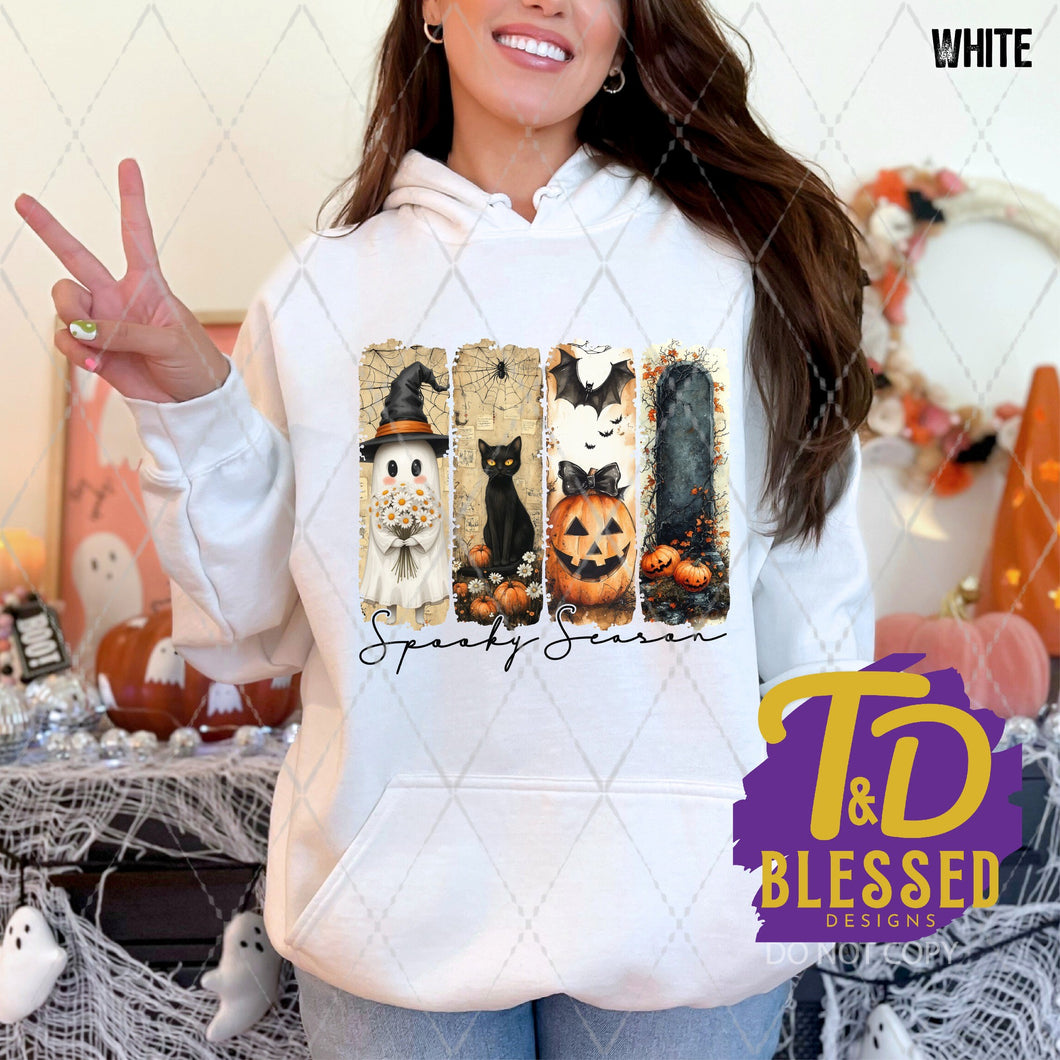 White hoodie featuring a 4-panel Halloween design with a ghost, black cat, jack-o'-lantern, and dark forest, with the words “Spooky Season” in elegant script below.